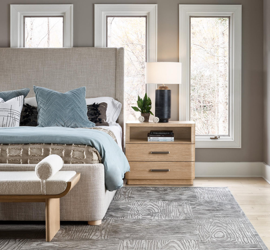 A grey headboard and bed with blue coastal-colored pillows