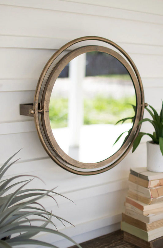 A round wall mirror hung in the living room