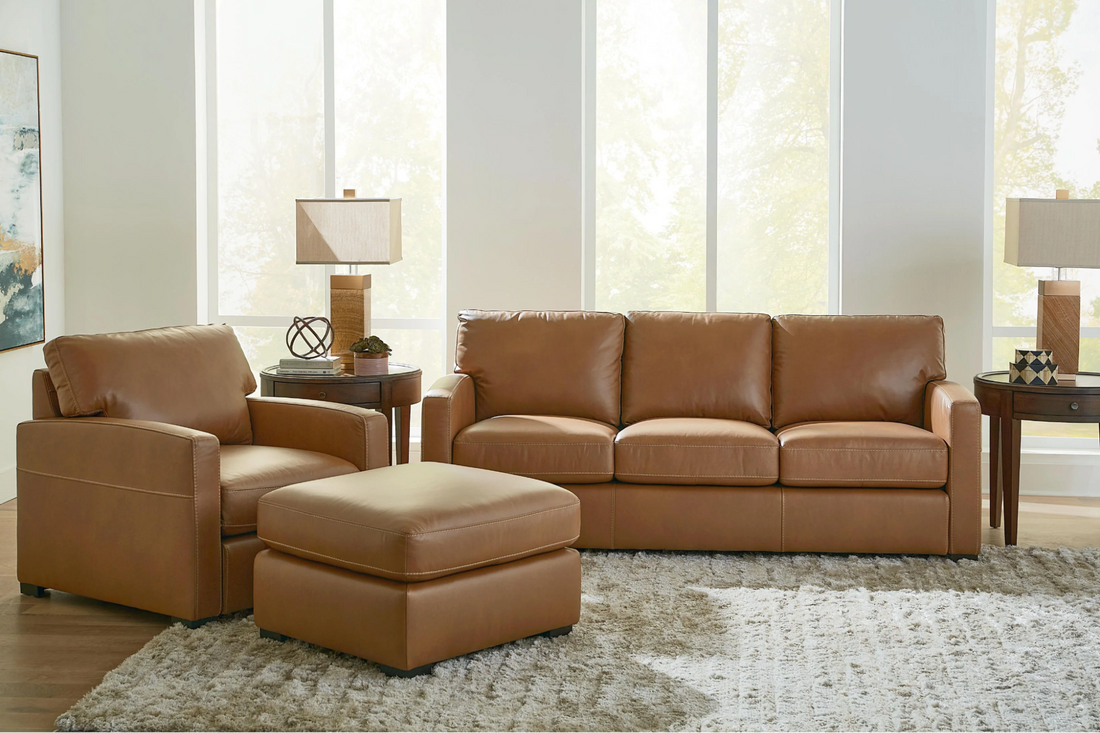 A brown leather sofa, armchair, and ottoman 