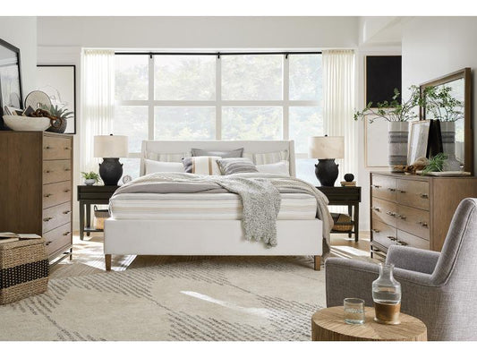 A neutral colored bedroom set, including a chest, dresser, nightstand, and bed frame