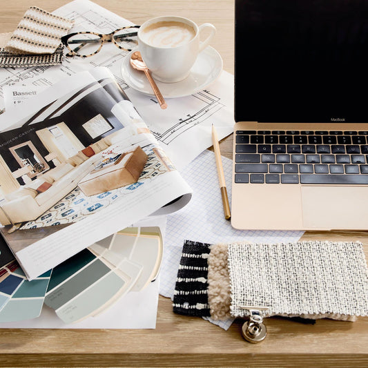 A laptop, catalog, and fabric and color samples