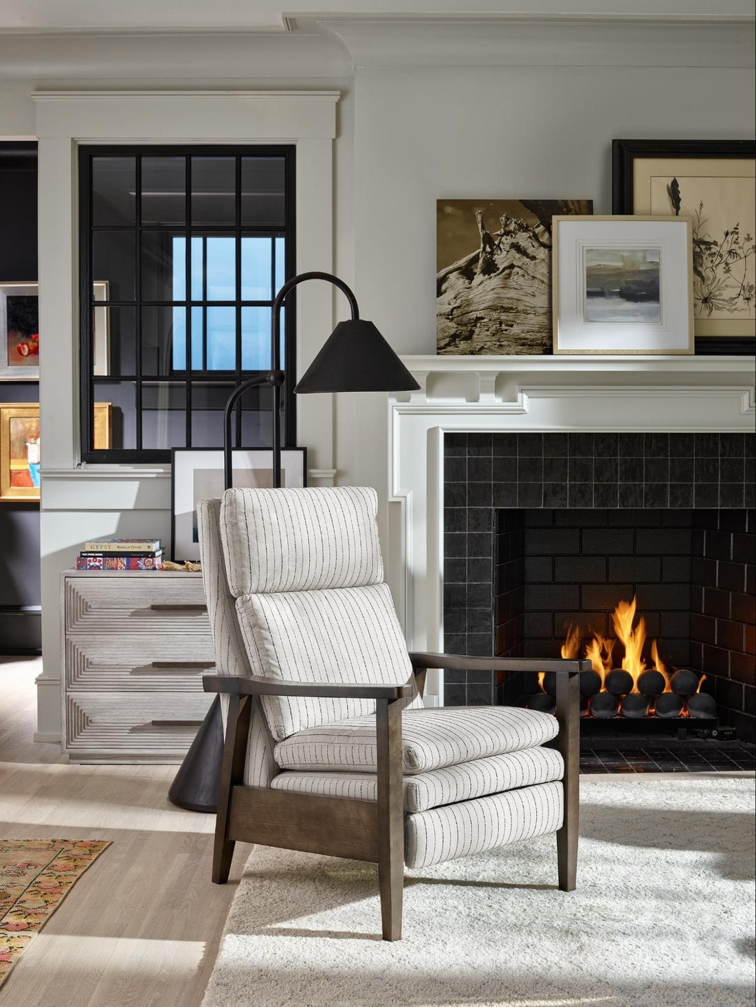 A white striped chair in front of a fireplace