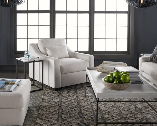 A white chair set, coffee table, and two layered rugs 